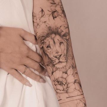 Lion and flowers tattoo on forearm in fine line style
