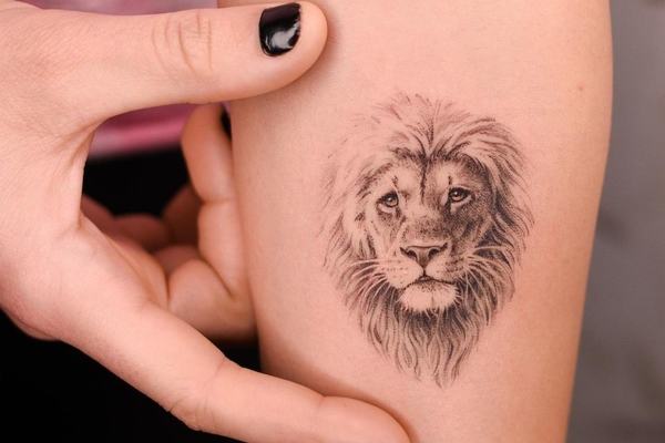 Small lion face tattoo with fine line shading
