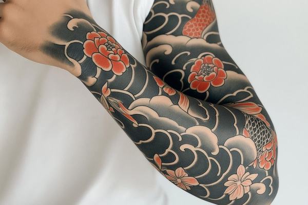 Koi fish sleeve tattoo with waves and flowers