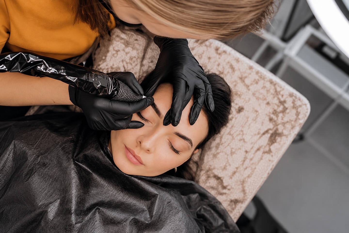 Close-up of eyebrow pigmentation using a permanent makeup machine