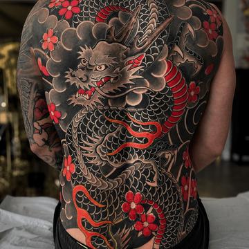 Japanese dragon back tattoo with red sakura flowers