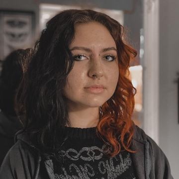 Close-up of a client in a Kaunas piercing studio with a septum ring and eyebrow studs, showcasing safe, professional facial piercing and jewelry selection.