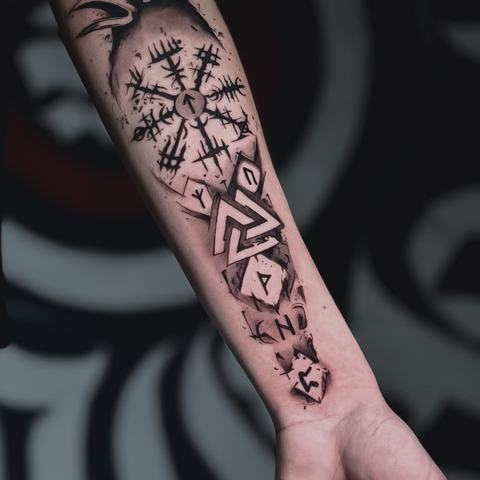 A blackwork forearm tattoo with a compass design, geometric patterns and sharp ornamental details