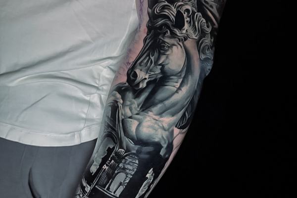Juodai pilka fantastinio motyvo tatuiruotė ant dilbio