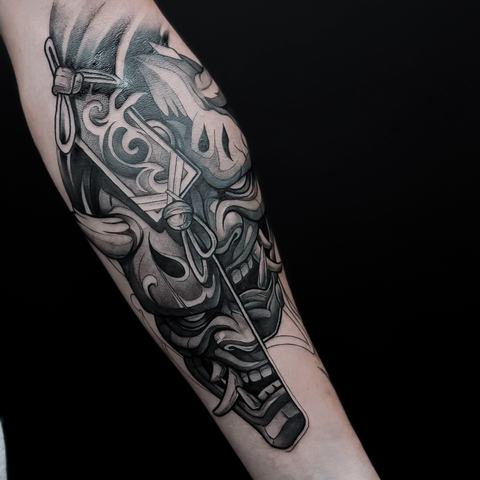 A detailed black and grey forearm tattoo featuring a wolf portrait with realistic shading