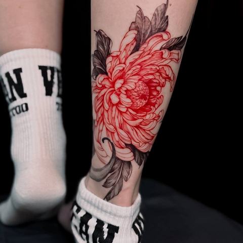 A detailed floral calf tattoo with a large red peony and dark botanical elements