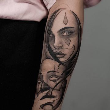 Juodai pilka veidų tatuiruotė ant dilbio