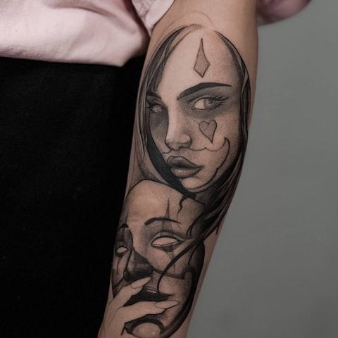 A surreal black-and-grey forearm tattoo combining abstract facial imagery, flowing shapes, and smooth shading for a distinctive artistic look.