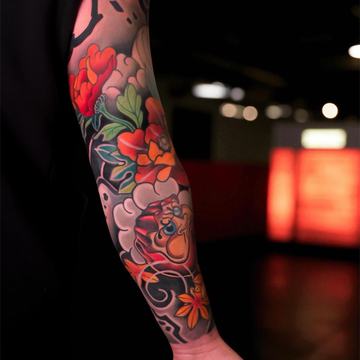 Colorful sleeve tattoo with peony, mask and floral details