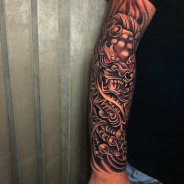 Dark forearm tattoo with dragon and ornamental waves