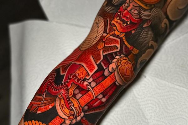 Samurai forearm tattoo with red and gold details