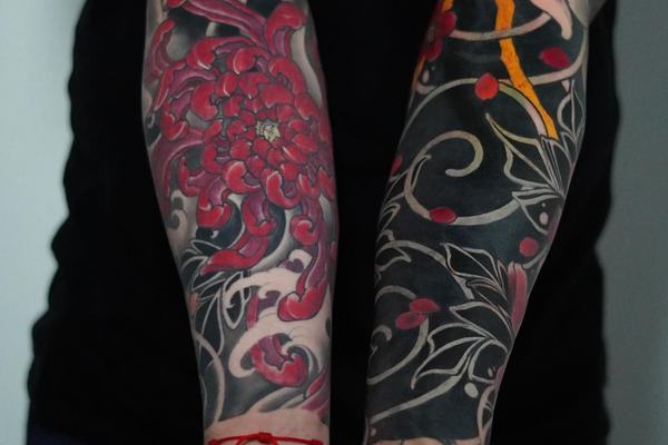 Forearm tattoo with chrysanthemum and wave patterns