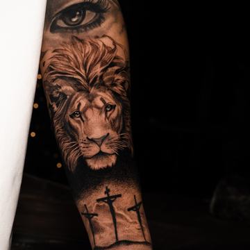 Lion portrait tattoo with eye and cross details